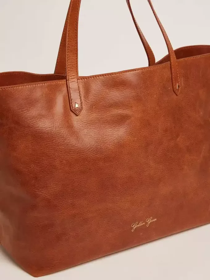 Borsa Pasadena in pelle martellata lucida color cuoio con logo dorato sul davanti Borsa Pasadena in pelle martellata lucida color cuoio con logo dorato sul davanti