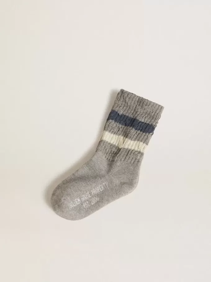 Calzini grigi da bambino con dettagli consumati e righe bianche e blu effetto usato
