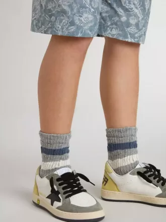 Calzini grigi da bambino con dettagli consumati e righe bianche e blu effetto usato