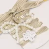 Pelle Lacci ricamati beige “Sparkling” con charm applicati in perline e charm dorato Pelle Lacci ricamati beige “Sparkling” con charm applicati in perline e charm dorato