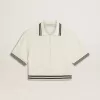 Polo da donna corta in cotone bianco consumato con bordi blu Polo da donna corta in cotone bianco consumato con bordi blu