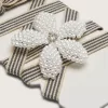 Skin “Vintage” lacci a righe nere e beige con ciondolo a forma di fiore