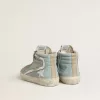 Slide da uomo in tela azzurra con inserti in pelle metallizzata argento Slide da uomo in tela azzurra con inserti in pelle metallizzata argento