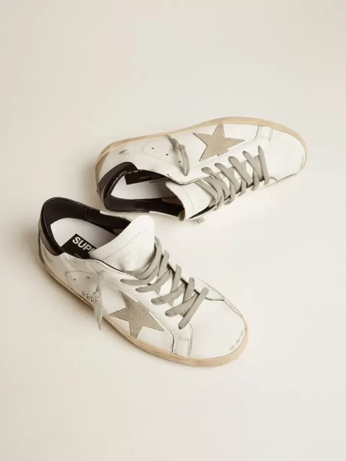 Super-Star da donna con linguetta nera sul tallone e scritte con borchie metalliche Super-Star da donna con linguetta nera sul tallone e scritte con borchie metalliche