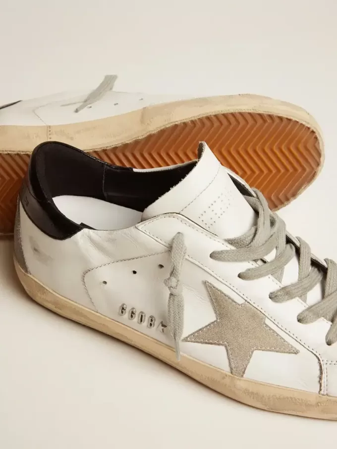 Super-Star da donna con linguetta nera sul tallone e scritte con borchie metalliche Super-Star da donna con linguetta nera sul tallone e scritte con borchie metalliche