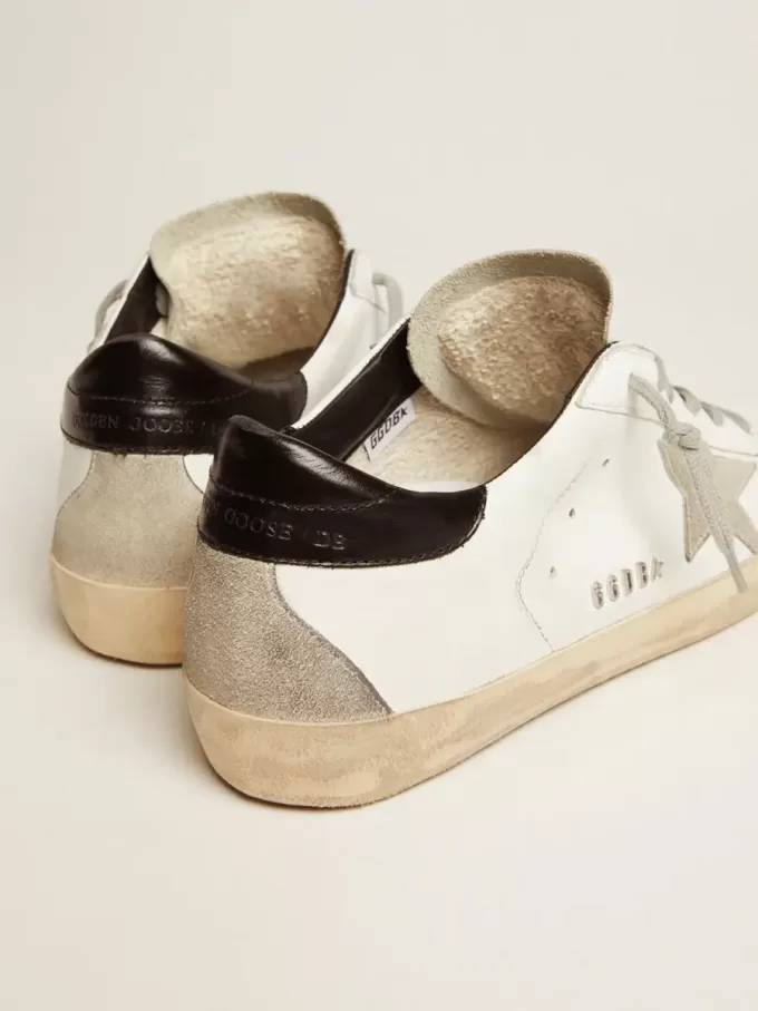 Super-Star da donna con linguetta nera sul tallone e scritte con borchie metalliche Super-Star da donna con linguetta nera sul tallone e scritte con borchie metalliche