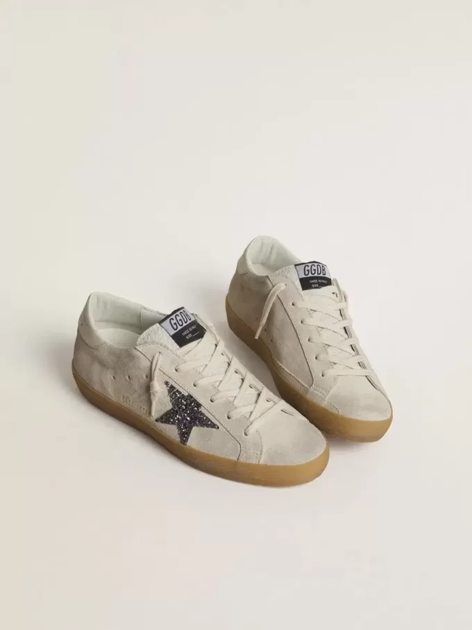 Super-Star da donna in camoscio grigio ghiaccio con stella glitterata argento e linguetta in pelle sul tallone Super-Star da donna in camoscio grigio ghiaccio con stella glitterata argento e linguetta in pelle sul tallone