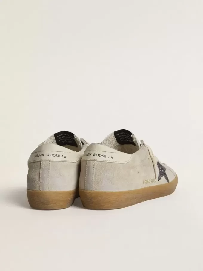Super-Star da donna in camoscio grigio ghiaccio con stella glitterata argento e linguetta in pelle sul tallone Super-Star da donna in camoscio grigio ghiaccio con stella glitterata argento e linguetta in pelle sul tallone
