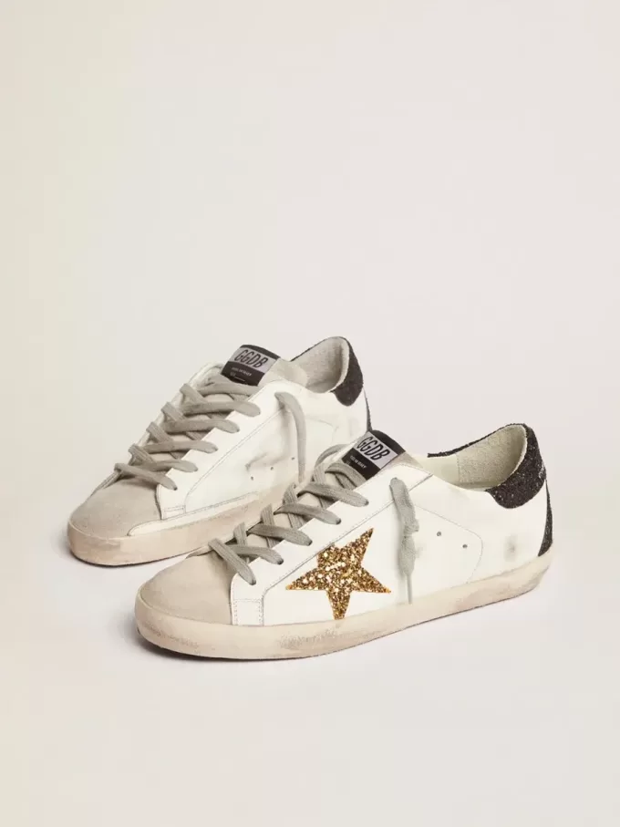 Super-Star da donna in pelle nappa con stella glitterata dorata e linguetta sul tallone glitterata nera Super-Star da donna in pelle nappa con stella glitterata dorata e linguetta sul tallone glitterata nera