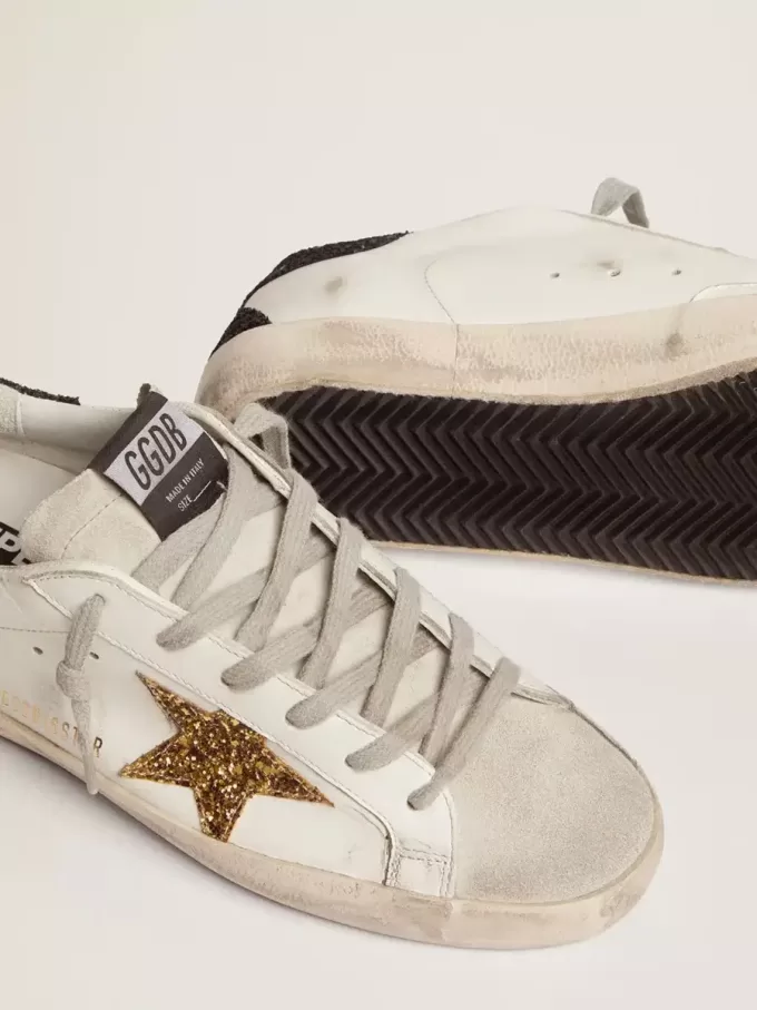 Super-Star da donna in pelle nappa con stella glitterata dorata e linguetta sul tallone glitterata nera Super-Star da donna in pelle nappa con stella glitterata dorata e linguetta sul tallone glitterata nera