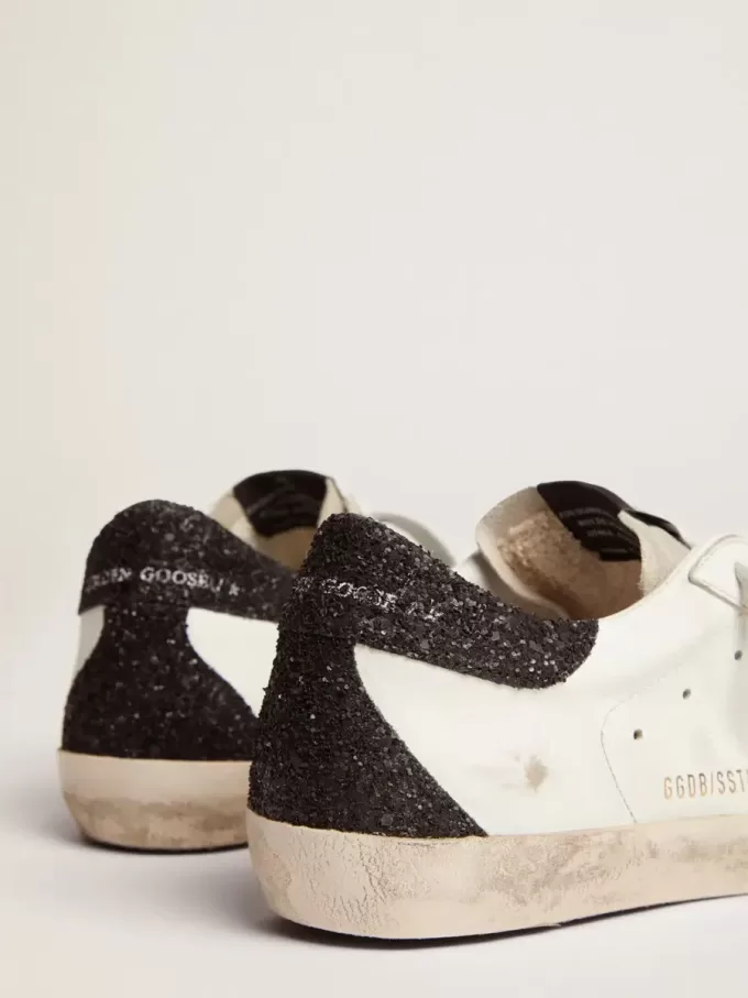 Super-Star da donna in pelle nappa con stella glitterata dorata e linguetta sul tallone glitterata nera Super-Star da donna in pelle nappa con stella glitterata dorata e linguetta sul tallone glitterata nera