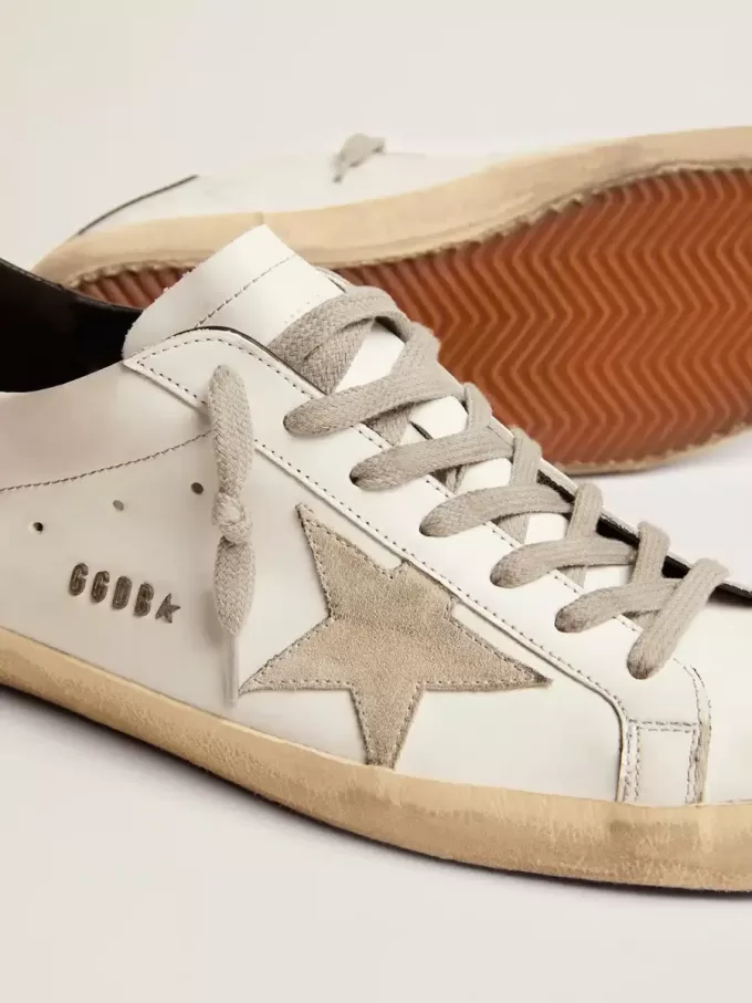 Super-Star da uomo con linguetta nera sul tallone e scritta con borchie metalliche Super-Star da uomo con linguetta nera sul tallone e scritta con borchie metalliche