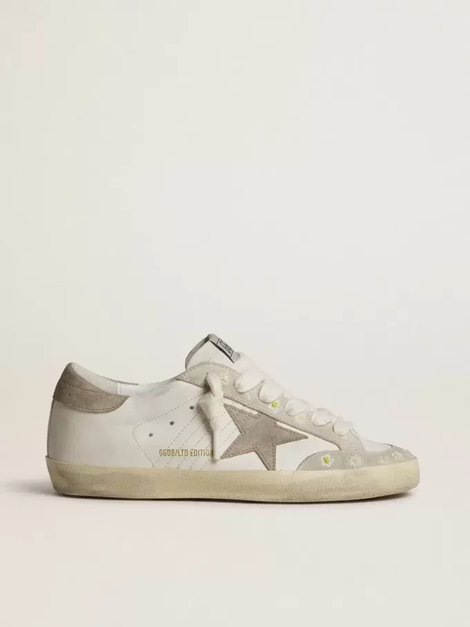 Super-Star LTD da donna con stella e linguetta sul tallone in pelle scamosciata beige e ricamo floreale Super-Star LTD da donna con stella e linguetta sul tallone in pelle scamosciata beige e ricamo floreale