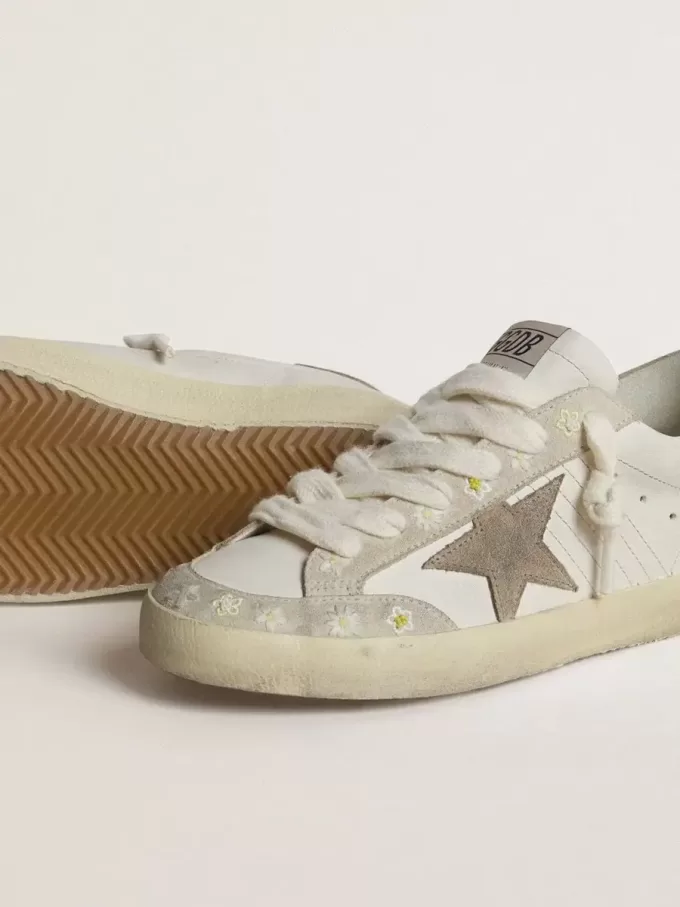 Super-Star LTD da donna con stella e linguetta sul tallone in pelle scamosciata beige e ricamo floreale Super-Star LTD da donna con stella e linguetta sul tallone in pelle scamosciata beige e ricamo floreale