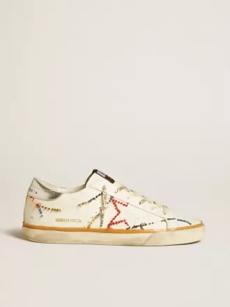 Super-Star LTD da donna con stella traforata e linguetta sul tallone in pelle metallizzata Super-Star LTD da donna con stella traforata e linguetta sul tallone in pelle metallizzata