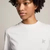 T-shirt bianca da donna con stella glitterata argento sul davanti T-shirt bianca da donna con stella glitterata argento sul davanti