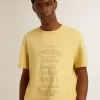 T-shirt da uomo in cotone giallo pallido con scritte sbiadite T-shirt da uomo in cotone giallo pallido con scritte sbiadite