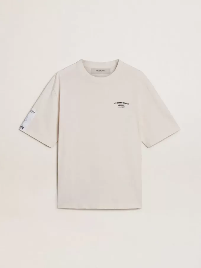 T-shirt unisex bianca con stampa mediterranea e toppa Pescheria Golden sulla manica T-shirt unisex bianca con stampa mediterranea e toppa Pescheria Golden sulla manica