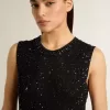 Top in maglia nera con paillettes e dettagli a contrasto
